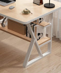 Modern desk with white metal legs and wooden tabletop, featuring a bookshelf with books and a lamp, in a home office setting.