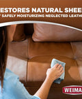 Person using Top Shelf Leather Cleaner And Conditioner Wipes on a brown leather sofa to restore its natural sheen.