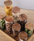 Straight Up Solid Airtight Coffee And Tea Storage Canister With Smooth Wood Lid, glass jars with wood lids on a tray.