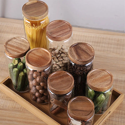 Straight Up Solid Airtight Coffee And Tea Storage Canister With Smooth Wood Lid, glass jars with wood lids on a tray.