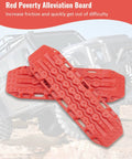 Red traction boards for off-road vehicles with textured surface for increased grip, placed on terrain background.