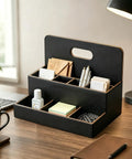 Black eight compartment desk organizer and mail holder on wood table with pens, envelopes, notes, and office supplies.