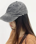Woman wearing a mesh baseball cap with detachable pearl hat chain, featuring metal beads and lobster claw clasp, side view