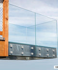 10 Pack 304 Stainless Steel Glass Railing Standoffs With Slick Wire Draw Texture used to secure glass panels in an outdoor setting.