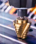 Close-up of Titanium Nitride Coated HSS Step Drill Bit with One Quarter Inch Hex Shank Ten Imperial Step Sizes in use on metal.