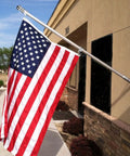 Top Notch 1.5 Inch Flag Pole Rings With Anti Wrap Swivel Clips And 360 Degree Rotating Aluminum Alloy Mounting Hardware For Rad Tangle Free Flag Flying With Rust Resistant Carabiners Two Pack holding an American flag in outdoor setting.