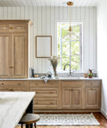 Modern Brass Pendant Light For Kitchen Island With Hand Blown Glass Shade over wooden kitchen cabinetry