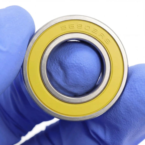 Close-up of a Stainless Steel Ceramic Hybrid Radial Bearing For Bike Hubs 15x28x7mm ABEC3, with yellow seal and marking SC6902RS