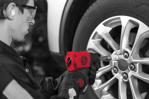 Mechanic using One Half Inch Air Impact Wrench With Two Inch Extension Anvil Twin Hammer Pistol Grip Industrial Repair And Assembly Tool In Durable Pistol Handle Design 715 Foot Pounds Of Torque And 970 Nm At Ten Thousand RPM on car tire