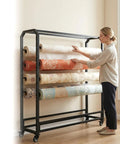Heavy Duty Rock Solid Fabric Roll Storage Rack With Adjustable Hanging Rod For Hassle Free Mobile Sample Organizer Of Vinyl Leather And Wallpaper Displays in use with various wallpaper rolls.