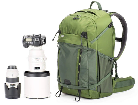 BackLight 36L Outdoor Adventure Camera Daypack Backpack in Woodland Green next to camera gear, showcasing ample storage.