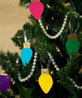 Colorful DIY Christmas ornaments made with Heavy Duty White Duct Tape 3 Pack 1.88 Inch By 30 Yard Rolls hanging on a tree