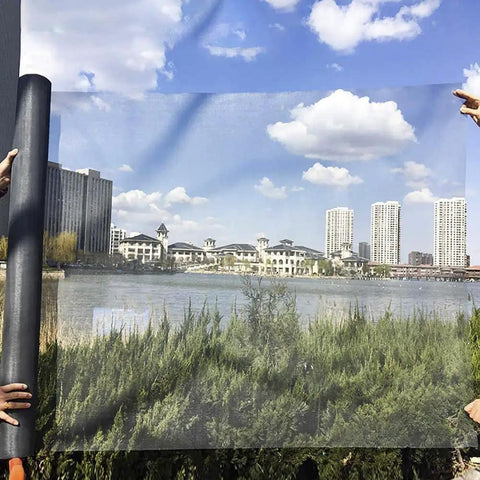 Fiberglass Window Screen Mesh Replacement Roll 39 Inch By 32 Point Eight Feet Gray held in front of cityscape