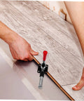 Fast Locking Level Fastener Push Pull Clamp For Vertical Fixtures in use on wood paneling, red handle, metal toggle catch.