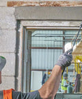 Worker using polymer modified structural repair concrete mix for vertical cracks in construction site doorway
