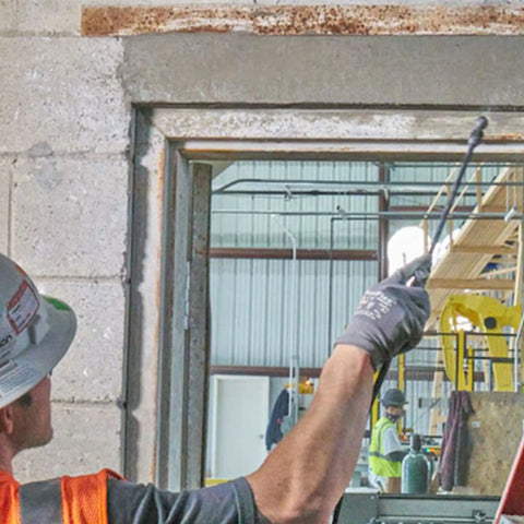 Worker using polymer modified structural repair concrete mix for vertical cracks in construction site doorway