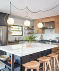 Plug In Globe Pendant Light Fixture With White Glass Ball And Brushed Brass Ring in modern kitchen setting