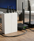 Keep The Wifi Alive With This Solid 7800mAh UPS Battery Backup powers your router and modem on a desk setup.
