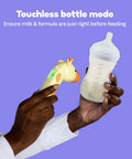Touchless bottle mode with Giraffe Themed No-Touch 3 In 1 Baby And Kids Thermometer For Infants With Quick Forehead Ear And Body Temp Readings, Kid Friendly Design To Keep Toddlers Chill During Temp Checks. shown beside baby bottle