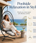 Woman relaxing in Comfy Hanging Egg Chair With Leg Rest And Stand In Gray by a pool, with plants in the background.