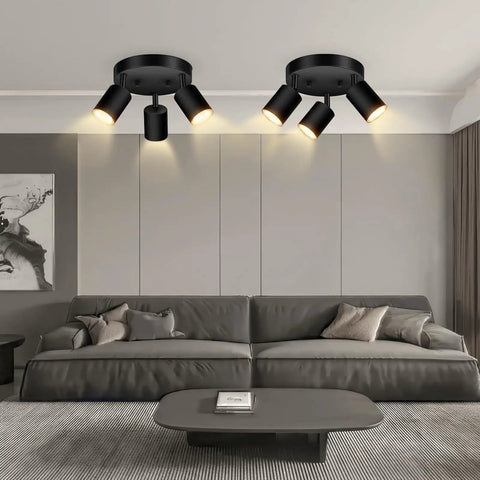 Three Light Matte Black Track Lighting Kit With Adjustable GU10 Heads installed in living room above couch.