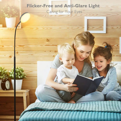Modern Black LED Floor Lamp That Shines Brighter For Cozy Living Room Ambiance next to a family reading on a bed