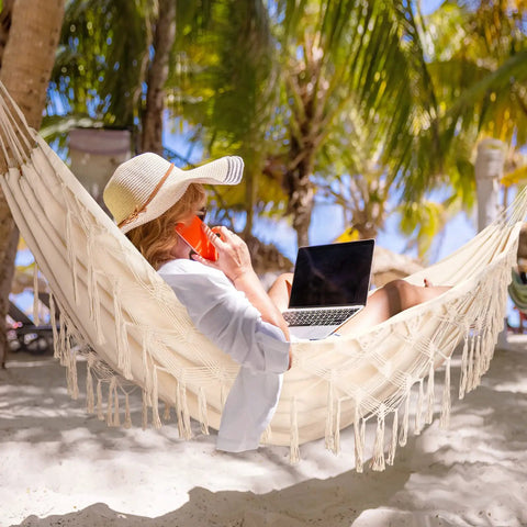 Person relaxing in Heavy Duty Double Hammock With 500 Lb Load Capacity, Tassel Trim, Fishtail Knit Design, on the beach