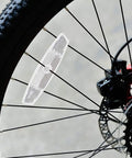 Close-up of white spoke reflector on mountain bike wheel, part of Night Ride Safe Bicycle Reflector Kit 6 Pcs for improved visibility.