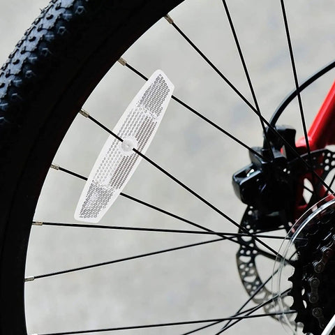 Close-up of white spoke reflector on mountain bike wheel, part of Night Ride Safe Bicycle Reflector Kit 6 Pcs for improved visibility.