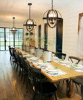 Three Light Vintage Pendant Chandelier In Matte Black With Spherical Shades in dining room setting