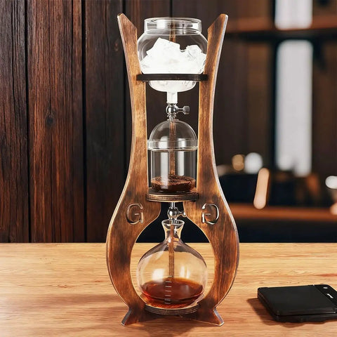 Top Shelf Portable Cold Brew Drip Tower And Iced Coffee Maker With Dual Adjustable High Borosilicate Glass Valves For Custom Flow and Smooth Batch Sipping, showing wooden structure and glass components.