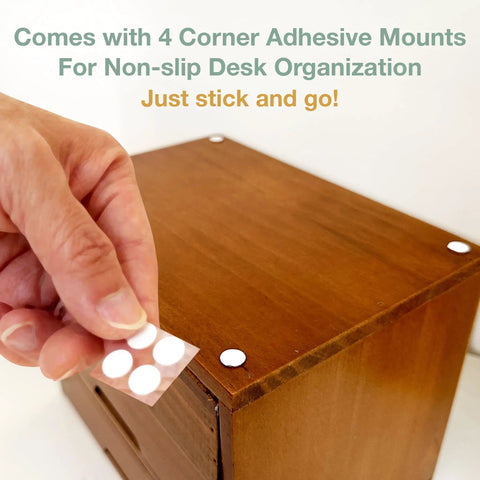 Hand placing adhesive mount on a dark mahogany cupboard for stability