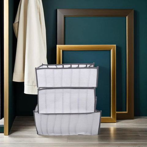 Total Closet Game Changer 3 Pack Seven Grid Foldable Bins With Grippy Handles, stacked white storage boxes for clothing organization.