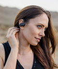 Woman wearing Shooting Ear And Hearing Protection Wireless Bluetooth Earbuds With ATACS Tech in an outdoor setting