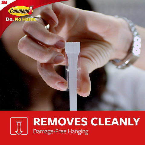 Hand removing adhesive strip from Ten Pound Extra Large Heavyweight Wall Hooks With Adhesive Strips Two Hooks And Six Strips No Drill No Mess Damage Free Mounting For Easy Home Organization And Storage Heavy Duty Hanging Solution For Kitchen Garage Office