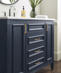 Vanity with Mulholland Champagne Bronze Cabinet Pull 5-1/16 Inch Center to Center Drawer Handle installed on dark blue cabinets.