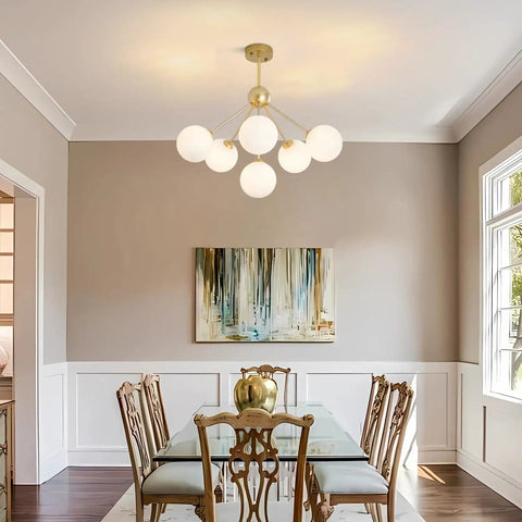 Dining room with Six Light Frosted White Glass Globe Sputnik Chandelier in Modern Gold Finish, mid-century style above table.