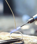 Close-up of Top Tier Copper Welding Rods Kit 4pcs For Jewelry Making, soldering wire being heated with a torch.