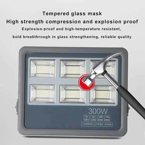 JUDYSSY 150-800W Led Flood Light Outdoor, Super Bright Led Security Light Ip66, 300W with a hammer showing impact resistance.