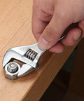 Hand using adjustable wrench from 57 Piece Home Tool Kit With Durable Plastic Toolbox For Quick Home Repairs And DIY Projects