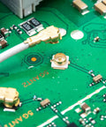 Close-up of Coaxial RF Connector Set For UFL Solder PCB Mount 50 Pack Socket Kit on green circuit board 3x3x1.25mm size