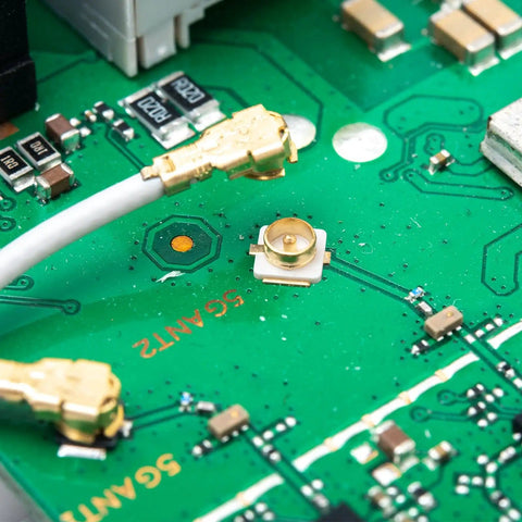 Close-up of Coaxial RF Connector Set For UFL Solder PCB Mount 50 Pack Socket Kit on green circuit board 3x3x1.25mm size