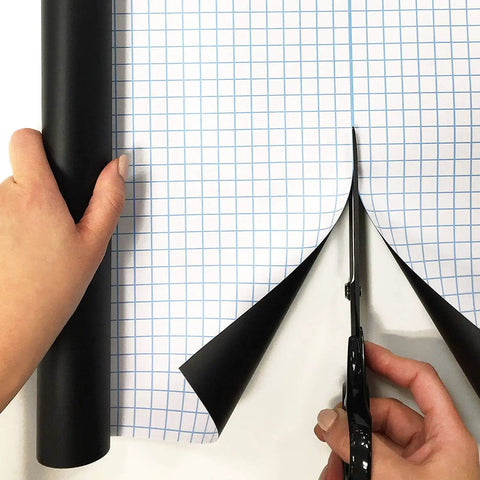 Person cutting Extra Large Chalkboard Peel And Stick Vinyl Roll Nine Feet Long With Five Color Chalk Included for DIY use