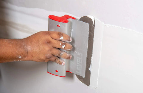 Hand using Drywall Skimming Blade Handle Adapter With Quick Release For On The Fly Length Changes Built Tough Pro Grade Tool.