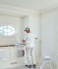 Painter using Pro Grade Masking Film Kit With Static Cling 8 Rolls of 48 In By 180 Ft Each indoors on a decorative cabinet
