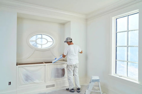 Painter using Pro Grade Masking Film Kit With Static Cling 8 Rolls of 48 In By 180 Ft Each indoors on a decorative cabinet