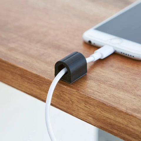 D Wings Cord Clips Nail Free Cable Organizer Kit Black on desk with phone cable secured, keeps cables tidy for home office use.