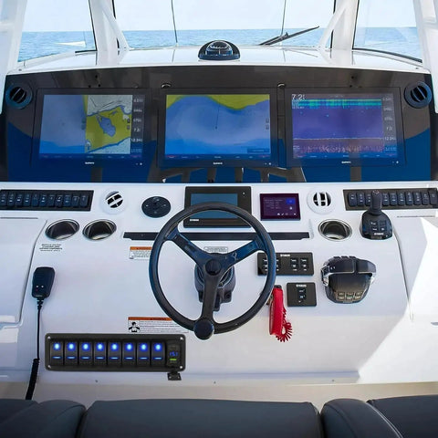 Boat dashboard featuring Beefed Up 8 Gang 12V Marine Rocker Switch Panel With PD Type C and USB Charger, steering wheel, and navigation screens.