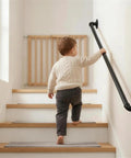 Child using Heavy Duty Four Foot Iron Stair Handrail In Matte Black Finish Rust Resistant Body For Indoor Or Outdoor Staircases.