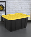 Six Pack Heavy Duty Stackable Industrial Totes Top Shelf Plastic Storage Bins With Secure Snap Lids Rock Solid Build For Garage Workshop And Warehouse Organization Black And Yellow view with yellow lid on gray floor.